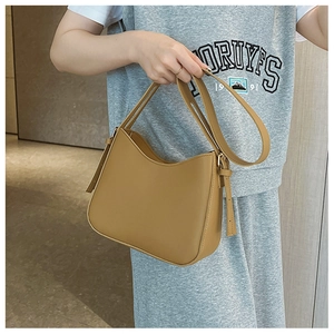 Détail d'un sac à bandoulière en cuir PU marron avec texture lisse et coutures fines