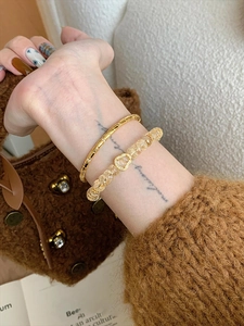 Détail du bracelet à pendentif cœur doré et perles de cristal jaune au poignet