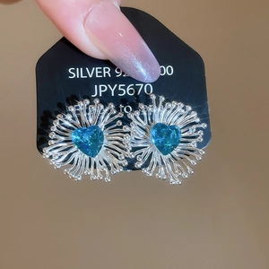 Gros plan sur des boucles d'oreilles en saphir bleu en forme de cœur et argent 925