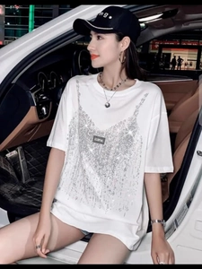 Λεπτομέρεια από λευκό βαμβακερό t-shirt με ασημένιες πούλιες σε εσωτερικό αυτοκινήτου