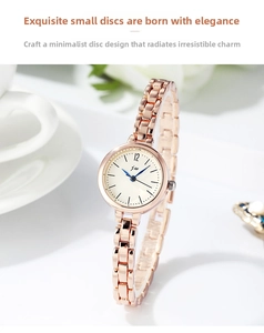 Close-up of a minimalist rose gold metal chain watch with a small round white dial
