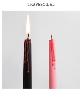 Detail of burning black and pink trapezoidal candles with red bleeding wax drip effects
