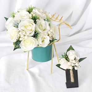 Detail of white silk rose boutonniere and bouquet with gold deer stand for weddings
