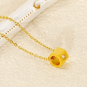 Macro detail of gold hexagon pendant with square-cut diamond on a fine O-chain