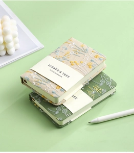 Stack of A6 linen notebooks featuring intricate flower and tree embroidery with paper bands