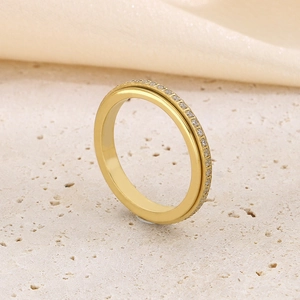 Luxurious gold-plated eternity ring with pavé sparkling crystals on stone background