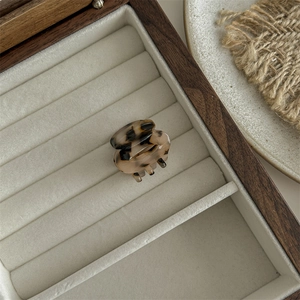 Detail of a leopard print hair claw clip on velvet lining inside a wooden jewelry box