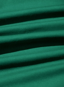 Macro shot of dark green cotton fabric showing soft texture and fine knit details
