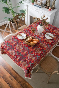 Close-up of red ethnic jacquard tablecloth with geometric patterns and fringe tassels
