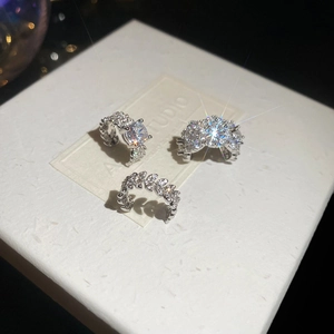 Detail of silver ear cuff set featuring zircon crystals on a white display box
