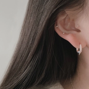 Close-up of minimalist S925 sterling silver hoop and ball stud earrings on model