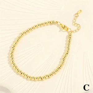 Detail view of the lobster clasp and adjustable extension chain on gold beaded bracelet