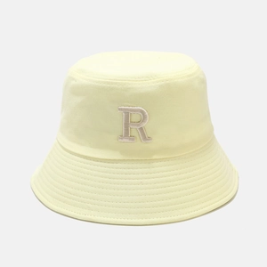Détail du chapeau bob jaune clair avec broderie R et coutures précises sur le bord