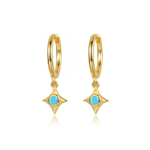 Detailed shot of gold-tone evil eye earrings with star charm and blue zircon stone