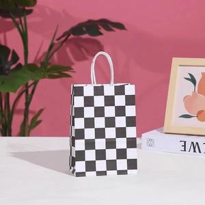 Detail of checkered paper gift bag featuring a black and white pattern and twisted handles