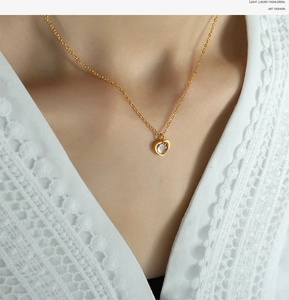 Macro detail of a golden heart necklace with clear crystal on lace fabric