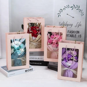 Detail of four colorful soap flower bouquets in gift bags with Love is Eternal ribbons