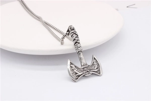 Close-up of vintage silver viking double-headed axe pendant with detailed engraving