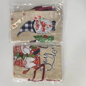 Detailed view of Christmas gnome and Joy burlap gift bags in clear plastic packaging