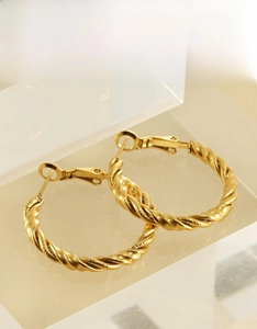 Macro shot of 18k gold-plated stainless steel twisted hoop earrings with stud backings