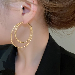Detailed close-up of 18k gold plated double hoop earrings with twisted texture