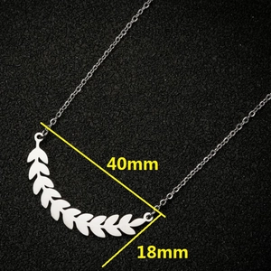 Silver wheat leaf pendant necklace in stainless steel on black textured background