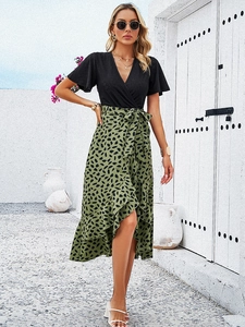 Détail d'une robe col V avec jupe à motif de feuilles vert olive et taille nouée