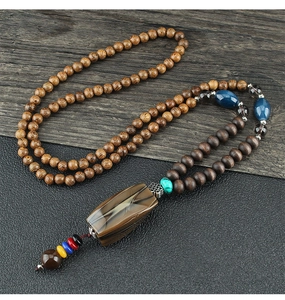 Detailed macro view of vintage wooden beads necklace with natural agate stone pendant