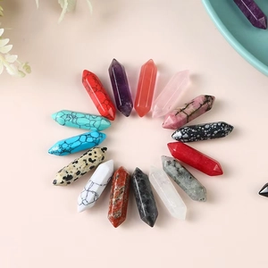 Flat lay of 14 double-pointed hexagonal gemstone pillars in various natural colors