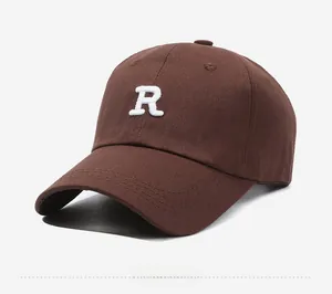 Close-up of white R letter 3D embroidery on a brown cotton canvas baseball cap
