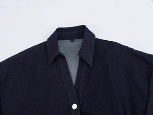 Détail du col d'une chemise en jean bleu foncé montrant l'étiquette taille S