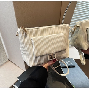 Detail of off-white corduroy crossbody bag with vertical textures and metal twist lock