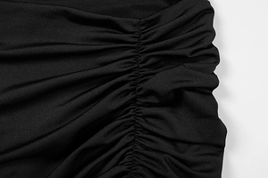 Detail of elegant black summer dress showing ruched side seam and textured stretch fabric