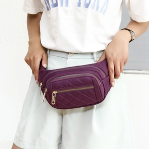 Purple quilted nylon fanny pack with multi-zippered pockets and gold hardware