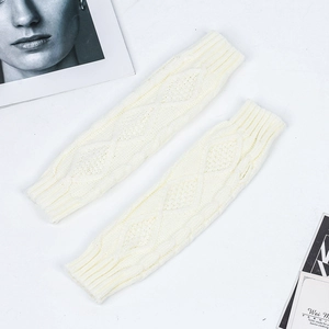 Detail of cream cable knit arm warmers with ribbed cuffs and classic braided pattern