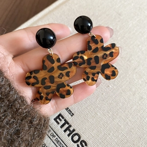 Nahaufnahme der Acryl-Ohrringe mit Leopardenmuster und glänzender schwarzer Perle