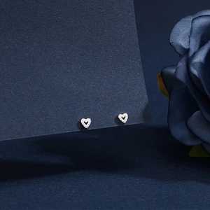Detailed macro view of S999 sterling silver heart stud earrings with cubic zirconia inlay