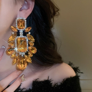 Primo piano di orecchini pendenti vintage con cristalli ambra su una modella molto elegante