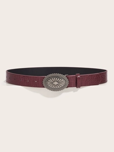 Close-up of burgundy crocodile pattern belt with large vintage silver buckle