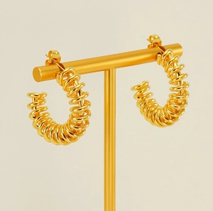 Detail of 18K gold-plated stainless steel spiral spring earrings on a display stand