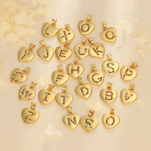 18K gold plated heart initial pendants with colorful cubic zirconia on silk background