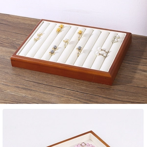 Detail view of wooden jewelry tray with white velvet lining for rings and bracelets