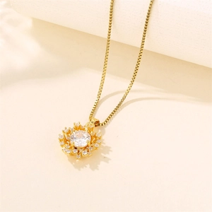Golden stainless steel sunflower necklace with sparkling zircon crystals on beige background