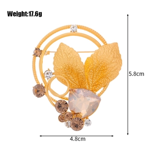 Elegant gold leaf brooch with crystals and size markings measuring 5.8cm by 4.8cm