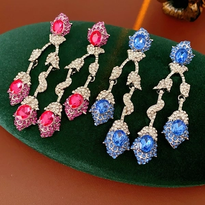 Detailed close-up of vintage flower tassel earrings with pink and blue crystal inlay