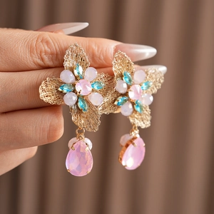Detail of vintage flower earrings with blue and pink crystals on gold metal mesh base