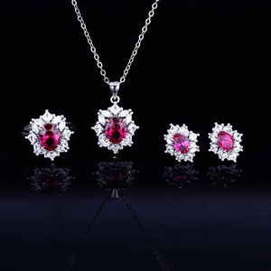Macro detail of red ruby gemstone jewelry set with silver necklace, ring and earrings