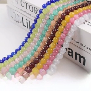 Detailed view of colorful natural eagle eye stone beads draped over an elegant white book