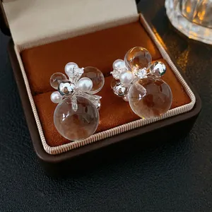 Elegant silver pearl earrings with zircons and transparent spheres in a jewelry box