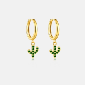 Macro detail of 18K gold hoop earrings with green zircon cactus pendant and reflection